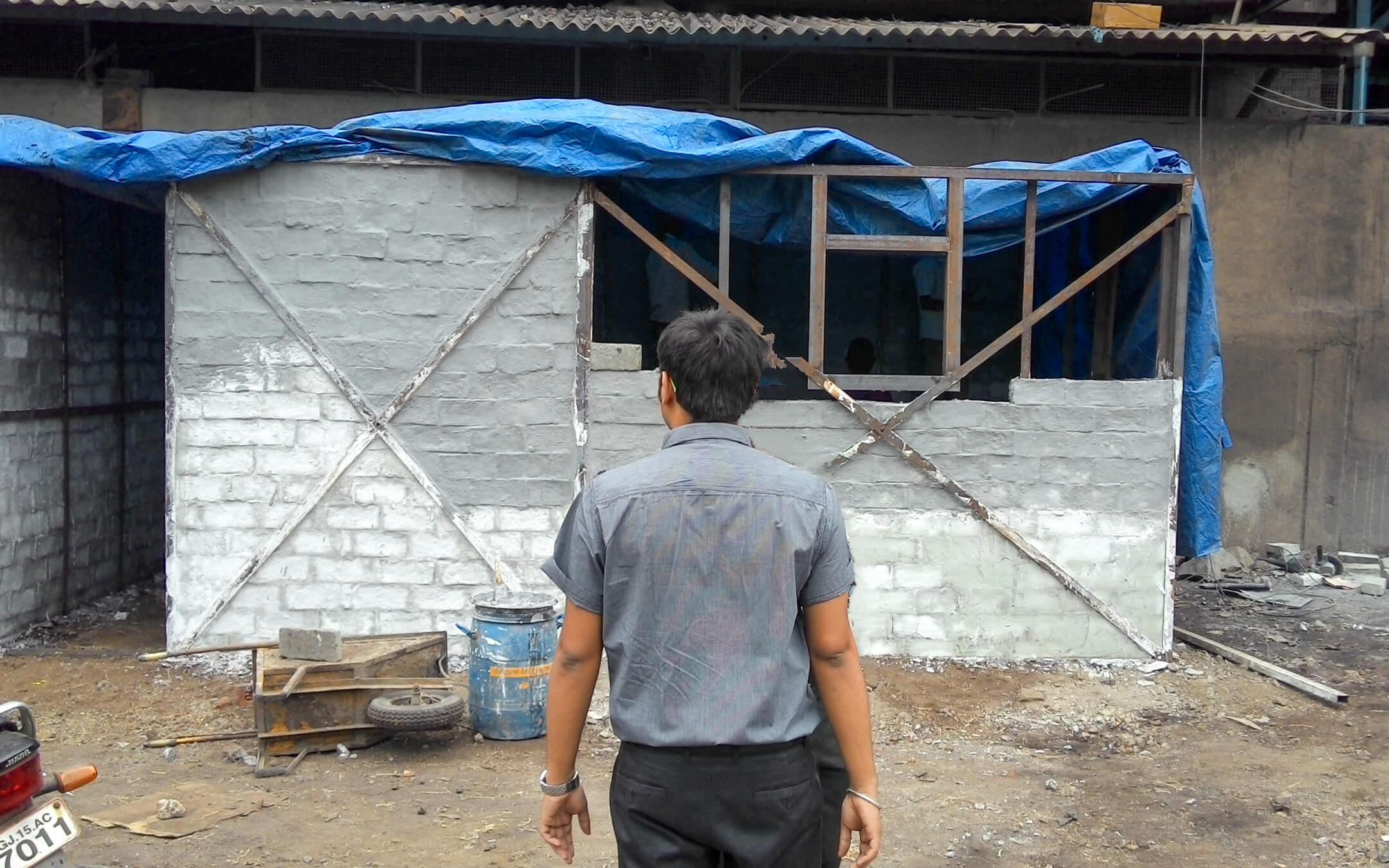 Binish Desai stands in front of a house built entirely from recycled bricks, all constructed with waste products.
Photo: Binish Desai