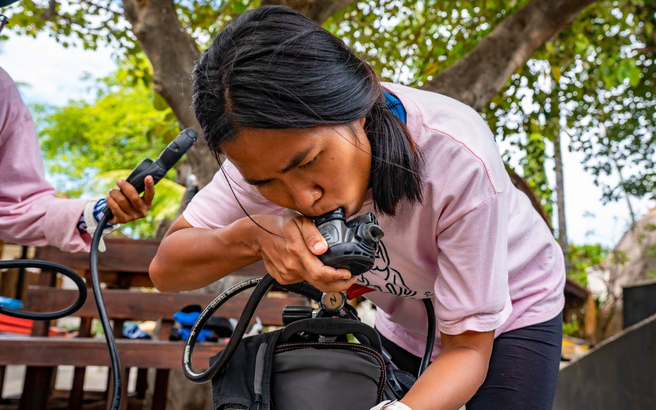 A member of Coral Catch does a quick, pre-dive check on her equipment.
Photographer: Charlie Fenwick