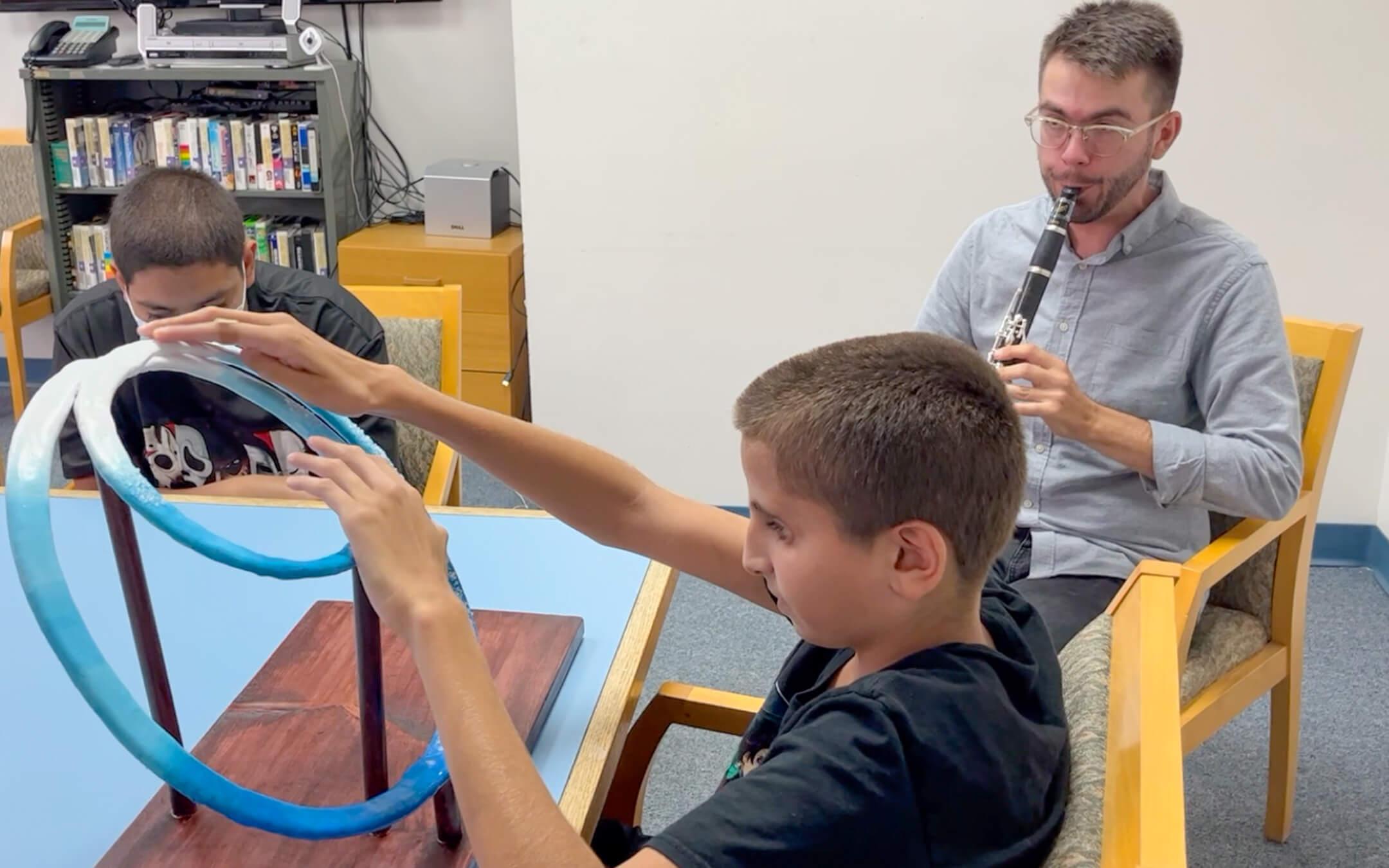 A professional musician improvises a musical piece that perfectly follows the hand movements of the student–allowing the young person to have a physical and aural experience of whale behaviour. 
Photo: Sound Explorations