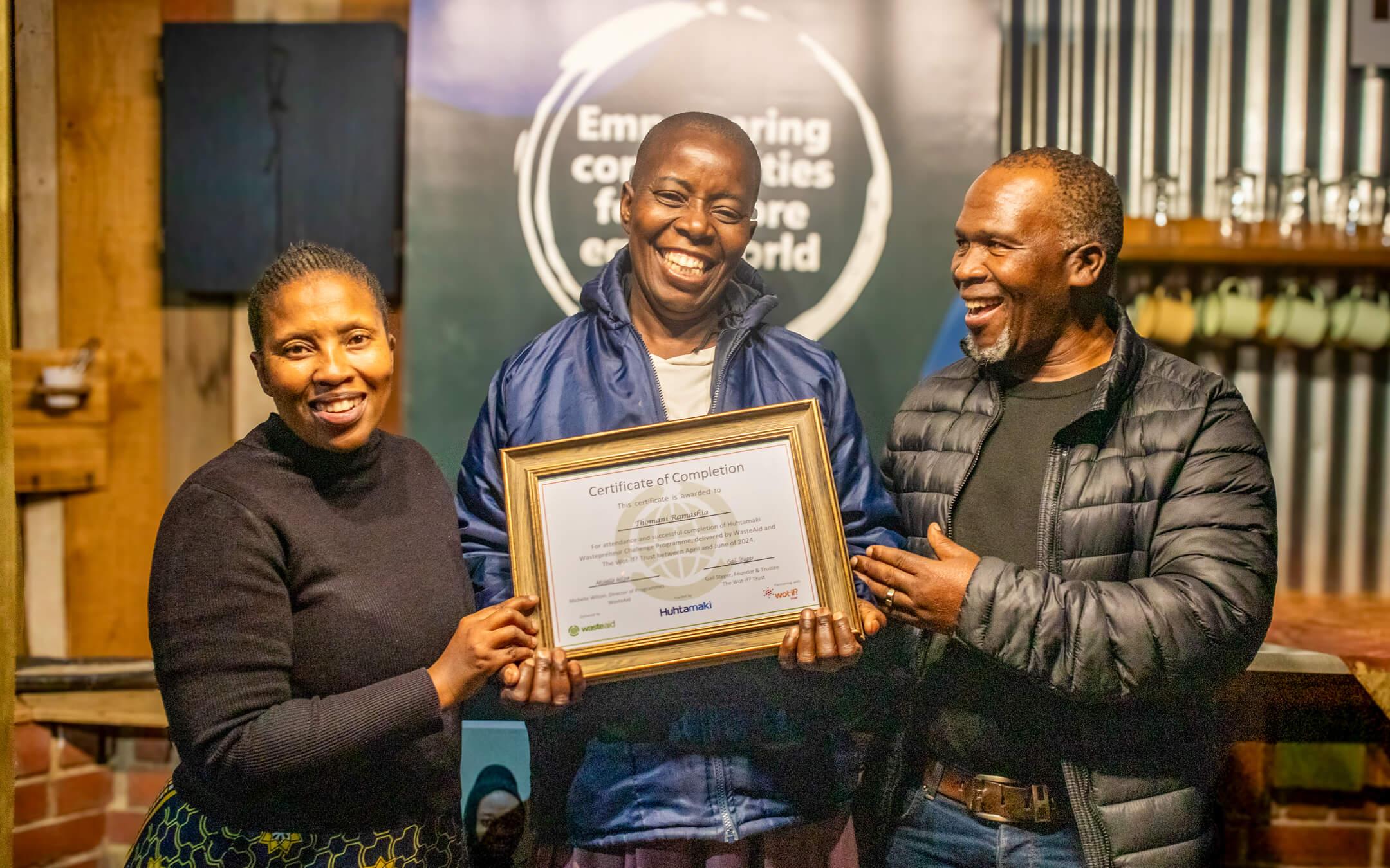 A South Africa Hutamaki Wastepreneur Challenge participant smiles with their certificate of completion.
Photo: WasteAid