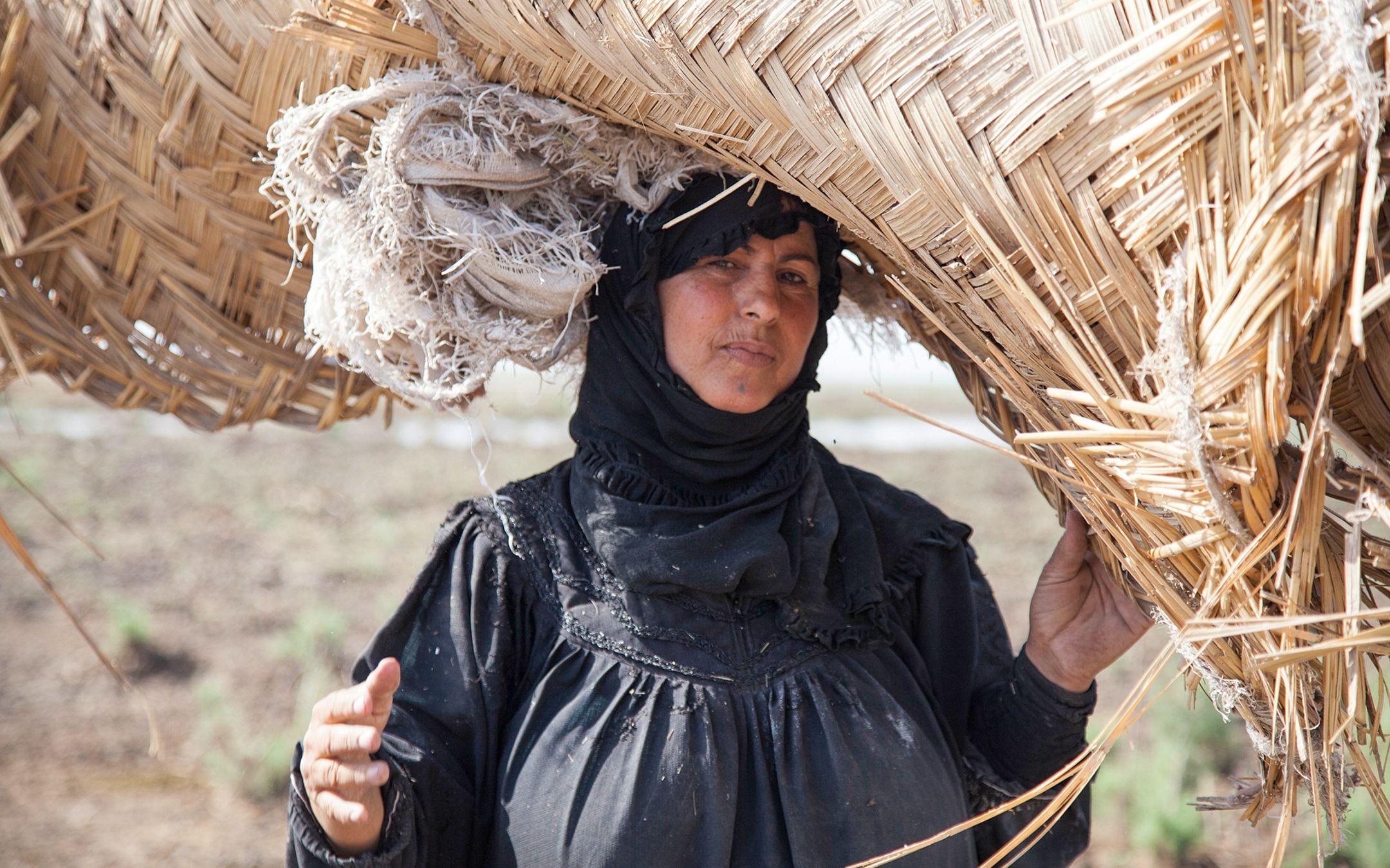 Marsh woman moving her reed house because the water was poisoned by fishermen. Mesopotamian Marshes 2011.
Photographer: Meridel Rubenstein