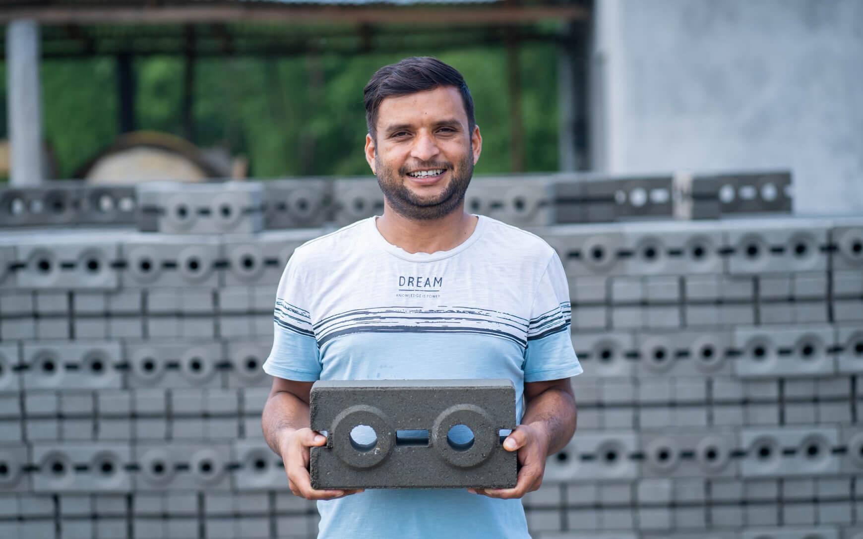 An entrepreneur holds an eco-brick designed and constructed by Build Up Nepal.
Photo: Build Up Nepal