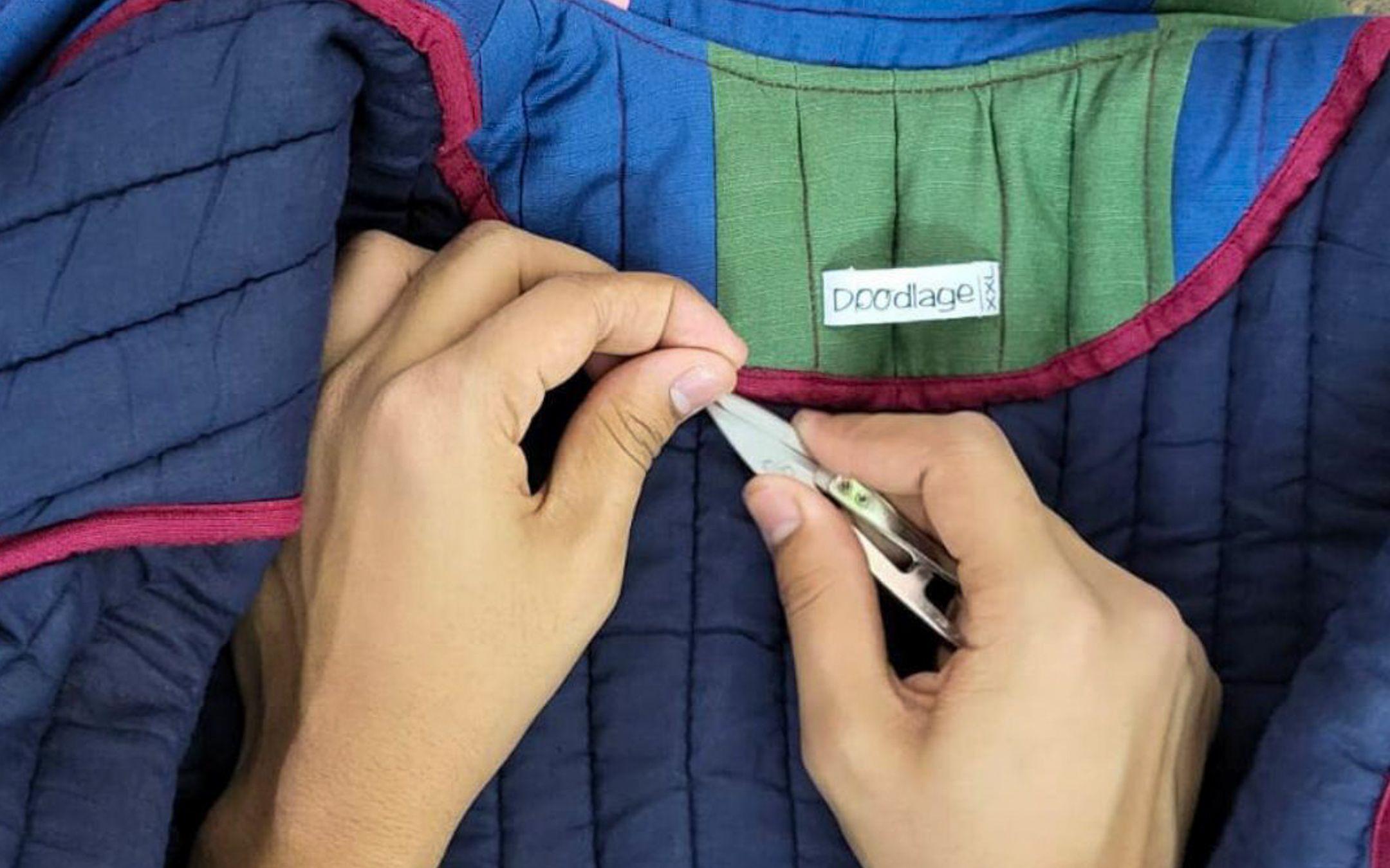 A garment worker carefully examines a completed piece of clothing, expertly checking for loose threads and strong seams.
Photo: Only Ethikal