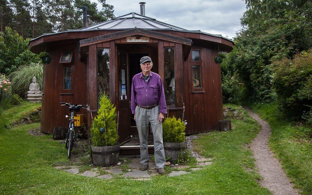 Roger Doudna outside ‘The Barrel’ – a cosy, wooden house he built from upcycled vats. 
Photographer: Neil Baird