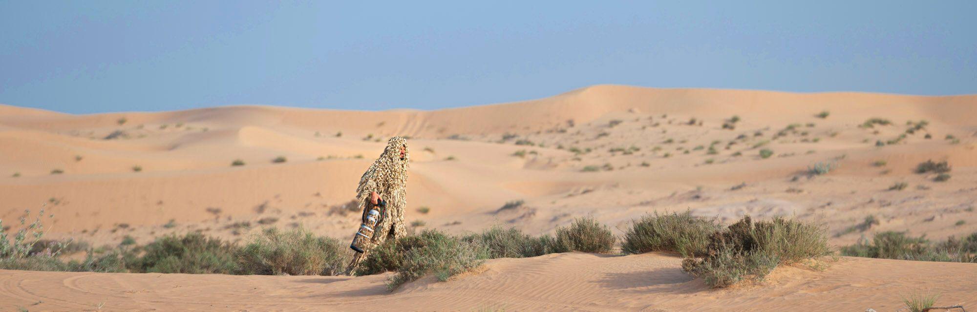 Ali bin Thalith enters the desert camoflauged to blend in and become a part of the environment. Photographer: Ali bin Thalith. Location: Dubai, United Arab Emirates.