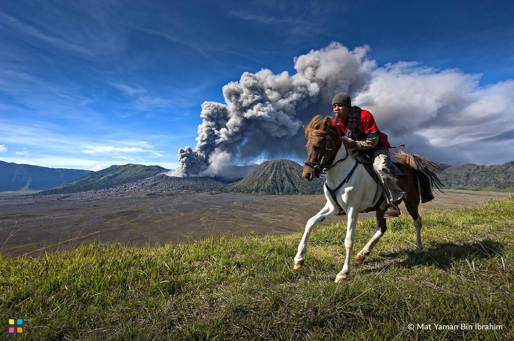 A rider on horseback races away from the smoking, active, Indonesian volcano, Mount Bromo.
Photographer: Matt Yaman Bin Ibrahim  Location: East Java, Indonesia